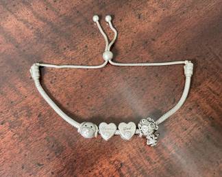 Authentic Pandora sterling silver charm bracelet marked "S925 ALE." Includes four charms: two engraved heart charms ("Dad" and "Auntie"), one dog charm, and one girl charm. Needs cleaned/polished and has minor bend in bracelet.
