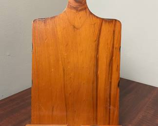 Solid wood stand shaped like a cutting board, with bottom ledge and hanging hole. Suitable for cookbooks or tablets.