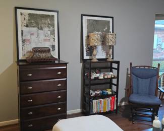 Dresser, knickknack shelf displaying a box collection, glider rocker, pair of neutral lamps,