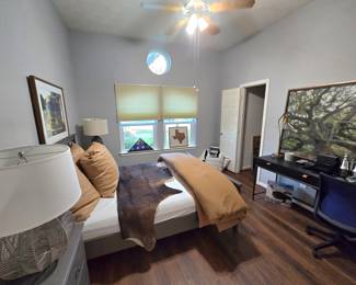 Cow hide rug, Queen bed with headboard, footboard, mattress, bed frame, lamps, nightstands, wall art and lots of decorative pillows, desk, desk chair, and more