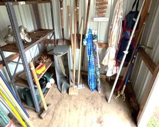 Variety garden tools, metal shelves, beach umbrella, patio umbrella.