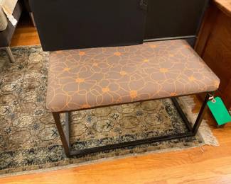 Floral ottoman with black metal base. Can be reupholstered with a different fabric.
