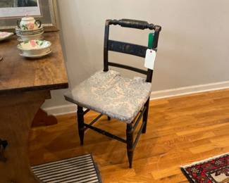 Antique hand painted black wood and cane chairs with light blue and damask patterned seat cushion