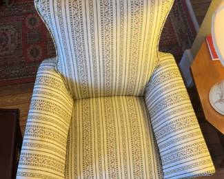 Wingback Armchair With a Floral and Striped Pattern Upholstery.