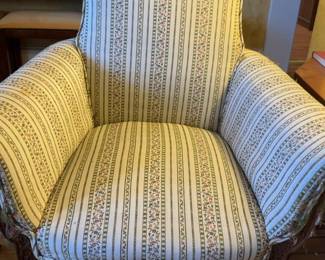 Wingback Armchair With a Floral and Striped Pattern Upholstery.