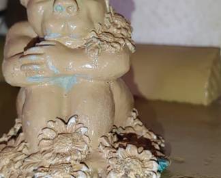 small statue of a gargoyle surrounded by daisies