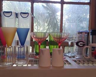 Lots of drinking glasses plastic and glass