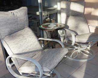 Two swivel sun chairs with foot stools.