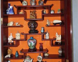 Rosewood Asian wall curio with bone like pieces, Netsukes, miniatures.