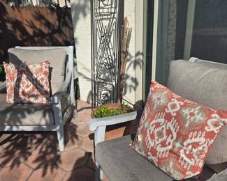 Pair large outdoor chairs, orange cushions, iron panels, planter