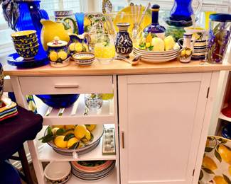 MOVEABLE KITCHEN ISLAND WITH LOTS OF COBALT AND YELLOW LEMONS.