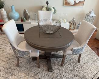 Round breakfast table with computer pad built-in easel with charging station and three R.K. Home dining chairs. 