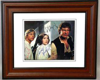 Autographed film photograph of Mark Hamill, Carrie Fisher, and Harrison Ford has double mat with frame