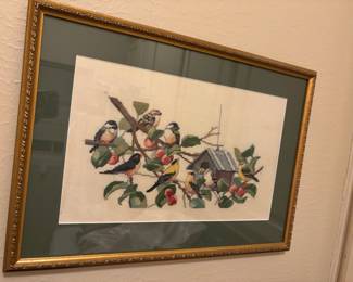 Framed cross-stitch embroidery of birds on a branch with a birdhouse