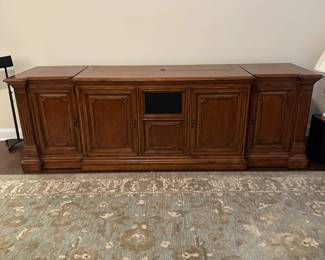 C111 - $1750. Sligh TV Lift Media Cabinet with Remote. Moves in 3 pieces. Each side piece is 24" wide x 27" deep x 34" tall. Center piece is 5' long x 28" deep x 34" tall. 
