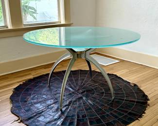 Green Glass Table on Metal Base with Leather Rug Underneath