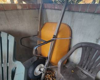 Wheelbarrow and plastic patio chairs