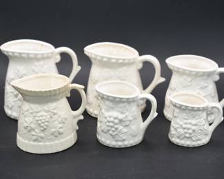 A Set of Six Enesco Ceramic Grapevine Pattern Measuring Pitchers
