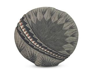 3352
Dorothy Sanchez (b. 20th century, Acoma Pueblo)
A polychrome canteen-form pottery vessel, early 21st century
Signed to underside: Acoma / N.M. / By: Dorothy Sanchez / [corn cipher] / [conjoined letters]
The three-color op-art-style vessel with circular form, featuring fine-line designs and a band of textured sawtooth and stepped designs running diagonally through the body
9.25" H x 10" W x 2.25" D
Estimate: $200 - $400