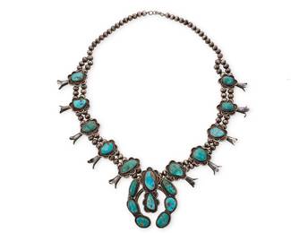 3383
A Southwest sterling silver and turquoise squash blossom necklace
Mid/late 20th century
Unmarked
With a central stone-set naja and ten blossoms, all set to double-strand of silver beads
27" L x 3" H
248.7 grams gross
Estimate: $700 - $900