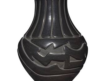 3308
Stella Chavarria (b. 1939, Santa Clara Pueblo)
A blackware pottery jar, late 20th century
Incised to underside: Stella Chavarria / Santa Clara
With deeply carved Avanyu motif to the body and banded feather motif to neck, with slip paint to carved areas
5.75" H x 4.25" Dia.
Estimate: $200 - $400