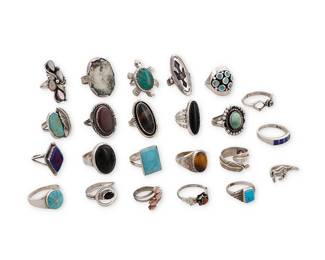 3396
A group of Southwest-style silver and stone set rings
Mid/late 20th century
Four variously marked for maker including: RB / EN / Charley / SC [within a cloud, for Silver Cloud, Inc NM shop]; nine marked for sterling
A mixed group of rings featuring various stones including turquoise, coral, lapis lazuli, tiger's eye, mother of pearl, and onyx, in various styles including bezel-set, cluster-set, mosaic inlay, and silver overlay, and figural motifs including a horse, a turtle, and a peyote bird
23 pieces
Ring sizes: 11 to 4.5
128.2 grams gross
Estimate: $200 - $400