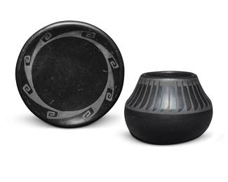 3301
Maria Martinez & Popovi Da (1887-1980 & 1923-1971, San Ildefonso Pueblo)
Two blackware pottery vessels, mid-20th century
Each incised to underside: Maria / Popovi
Each with black on black designs, comprising a small jar with banded feather motif to shoulder, and a small plate with swirling hook motif
2 pieces
Jar: 3.375" H x 4.25" Dia.; Dish: 1" H x 5.625" Dia.
Estimate: $800 - $1,200