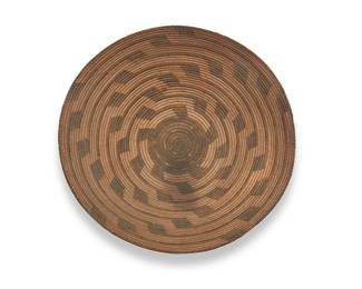 3294
A large Pima basket
Early/mid-20th century, Akimel O'odham; Southwest United States
A coiled basketry tray with ancestral pueblo motifs of swirling stepped bands issuing from a dark center
5.5" H x 15.75" Dia.
Estimate: $300 - $500
