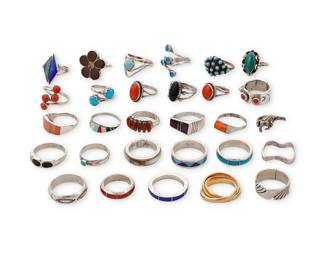 3402
A group of Southwest-style silver and stone set rings
Mid/late 20th century
Eight variously marked for maker: Paloma / RG+/ZI / TK [stylized with double feather, for Ray Tracey (Navajo/Diné)/Knifewing Segura] / ANC / GK / DT / C.L.T. [for Linda Tsalate, Zuni] / -C [inverted, unknown mark]; nine marked for sterling
Featuring silver and gold-toned rings in various stones including turquoise, coral, malachite, mother of pearl, and onyx, in various styles including bezel-set, cluster-set, mosaic inlay, and silver overlay, and one figural motif ring of a horse
29 pieces
Ring sizes: 9.5 to 4.5
96.0 grams gross
Estimate: $200 - $400