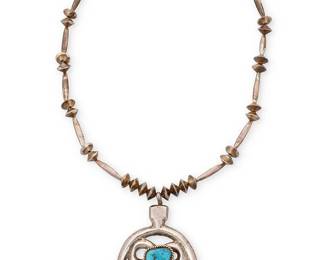 3387
A Southwest sterling silver and turquoise naja pendant necklace
Mid/late 20th century
Unmarked
Comprising a cast silver naja with central set turquoise, suspended from a single strand of silver beads
24" L x 3.75" H
97.5 grams gross
Estimate: $600 - $800