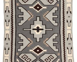 3255
A Jackie Begay Navajo Teec Nos Pos rug
Jackie Begay (b. 20th century, Diné)
Late 20th century
Woven in grey, white, black, brown, and cream wool with floating stepped diamond and various floating motifs to center, with a feather-style motif border to all sides
63" H x 48" W approximately
Estimate: $600 - $900