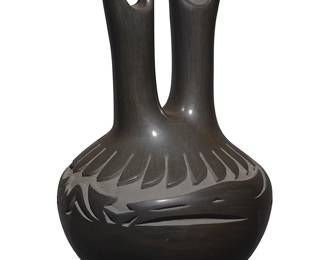 3310
Barbara "Jo-Povi" "Cactus Flower" Martinez (b. 1947, Santa Clara Pueblo)
A blackware pottery wedding vase, late 20th/early 21st century
Incised to underside: Barbara Martinez / Santa Clara Pueblo
The double-spouted handled vase with deeply carved Avanyu motif to the body and banded feather motif to shoulder, with slip paint to carved areas
13.25" H x 8.625" W x 8.375" D
Estimate: $400 - $600