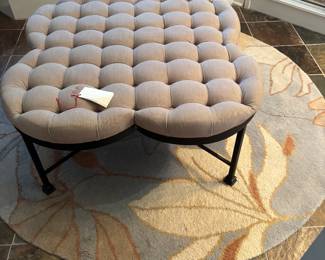 clover shape tufted linen ottoman and an aged-black metal base round area rug