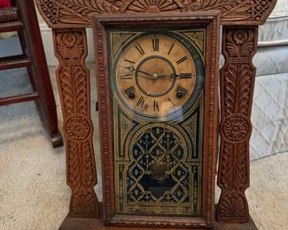 Ornate carved wooden E. Ingraham mantle clock with Roman numeral dial.