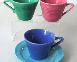 These three Homer Laughlin cups include two in the Harlequin style (green and blue) and one in pink that doesn't look like Harlequin, but it might be. Also not sure if the saucer is Harlequin or Fiestaware.