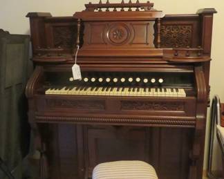 19th Century pump organ & seat. More ornate parts next to organ.