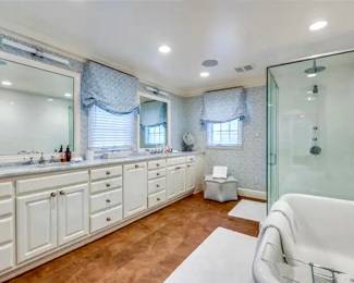 Exquisite Primary Bathroom Includes Large Seamless Glass Shower Enclosure, Soaking Tub, Window Treatments, Toto Toilet, White Cabinetry and Faucets