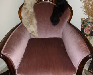 Oversize wood framed antique chair (those are fur collars hanging over the back)