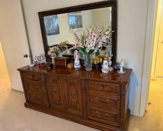 Solid wood dresser with ornate framed mirror—plenty of storage and timeless appeal.