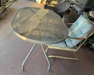 Oval glass-top patio table with metal frame—sturdy and perfect for outdoor dining or garden spaces.