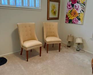 Set of two cream tufted accent chairs with wood legs—comfortable and elegant seating, perfect for a bedroom or sitting area.