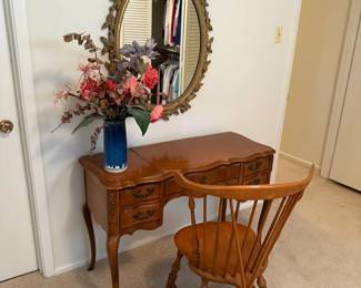 Charming vintage vanity with carved drawers, matching maple spindle chair, ornate gold oval mirror.