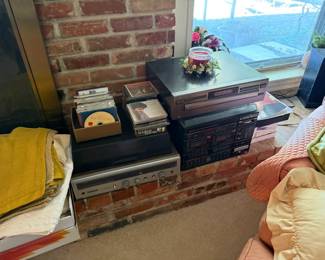 Assorted JVC and Panasonic stereo components with classic CD collection—perfect for vintage audio enthusiasts.