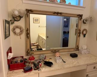 Vintage framed mirror and assorted jewelry and trinkets.
