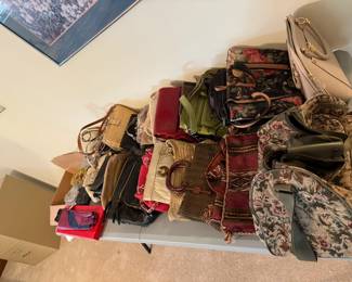 Collection of vintage and modern handbags, including tapestry, leather, and woven styles—various sizes.
