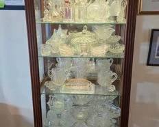 Tower style curio cabinet with glass shelves and lights, colored and clear glass collections 