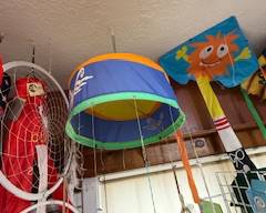 Bright blue and green hanging windsock with playful ocean-themed design, perfect for porch or patio décor. Surrounded by dreamcatchers and lanterns for a colorful d