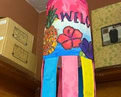 

Tropical “Welcome” windsock with pineapple and hibiscus artwork and bright multicolor streamers. Vibrant hanging décor for porch, patio, garden, or entryway.