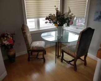 Glass table; upholstered chairs; faux botanicals