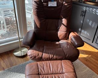 Brown leather stresses chair and ottoman
